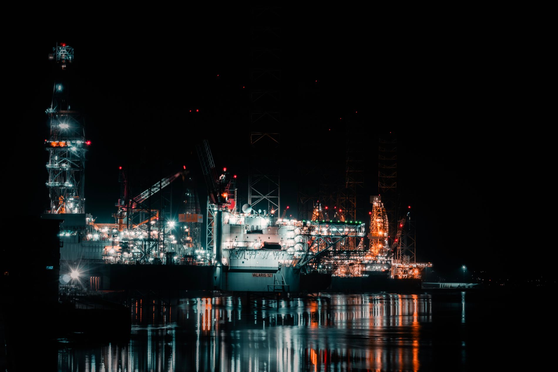 An offshore drilling platform lit up against the night sky